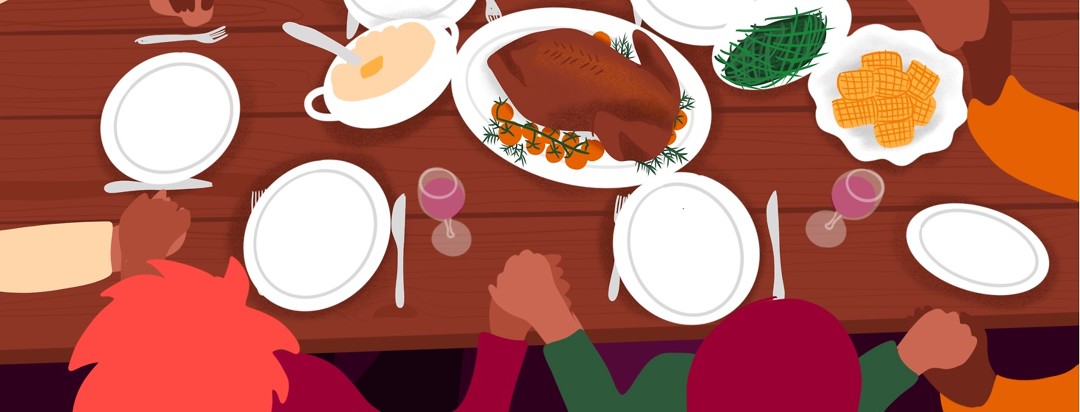 A family holds hands around a holiday dinner table