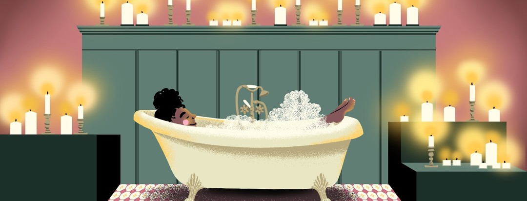A woman relaxes in her bath surrounded by candles