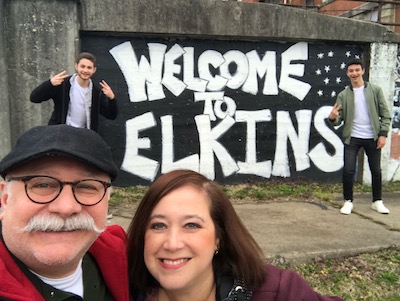 Ivy in front of Welcome to Elkins sign with mayor and sons