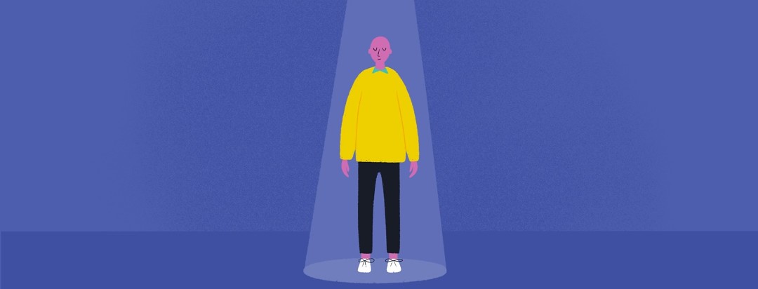 A person stands in the middle of a spotlight