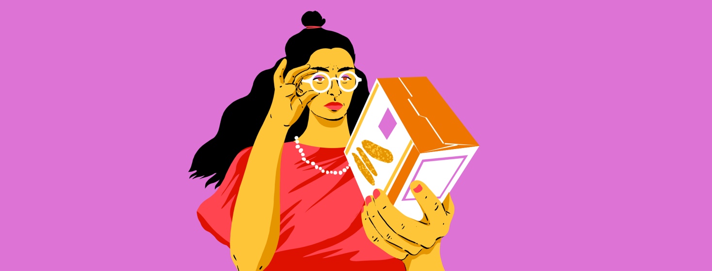 A woman reads the nutrition facts on the back of a box