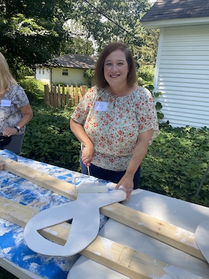 Ivy painting a white ribbon