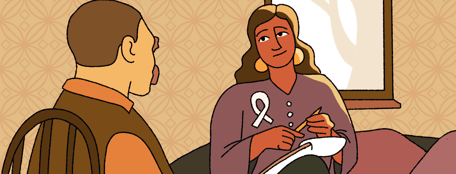 A man talking to a therapist who is wearing a cancer awareness ribbon