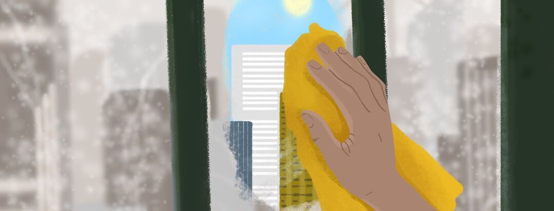 A hand wiping dirt and grime off of a window to show a more clear view of a city.
